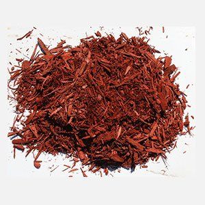 Pile of red-dyed wood mulch on a white surface.
