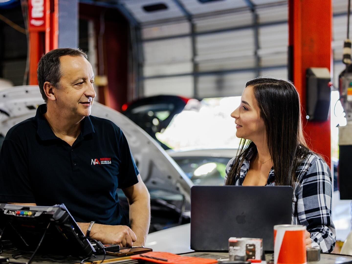 Team members in the shop with laptop | Northrich Automotive