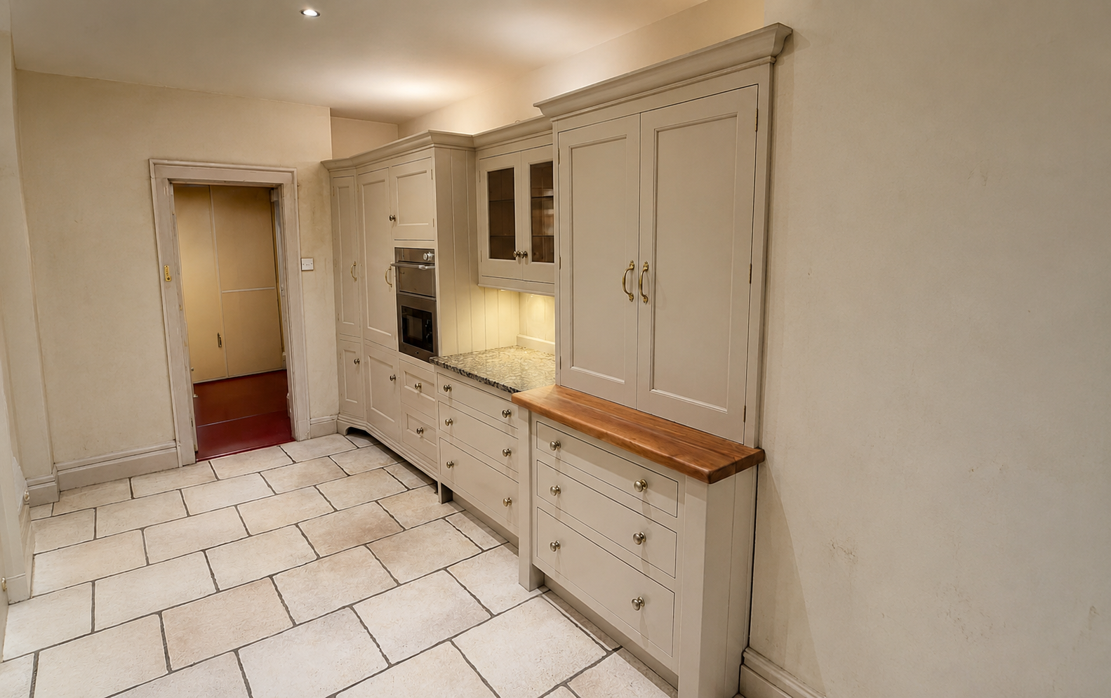 Warm wooden kitchen with marble island, stainless range, and a sunlit window over the sink.