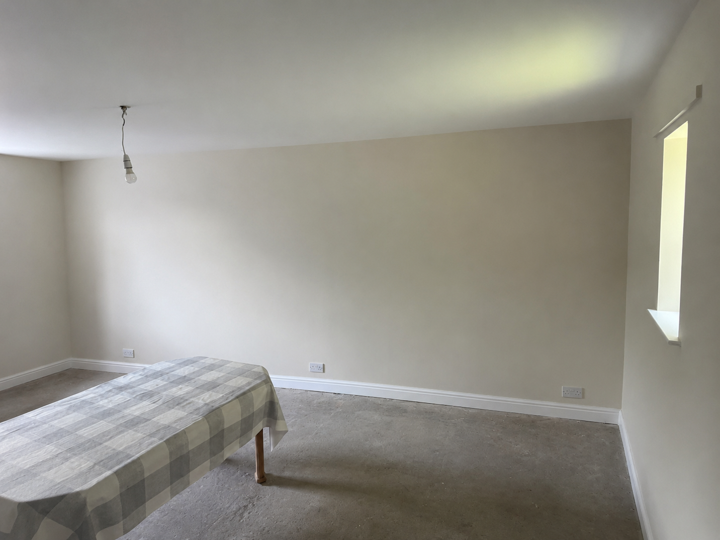 Empty room with gray accent wall, white baseboard, and carpeted floor