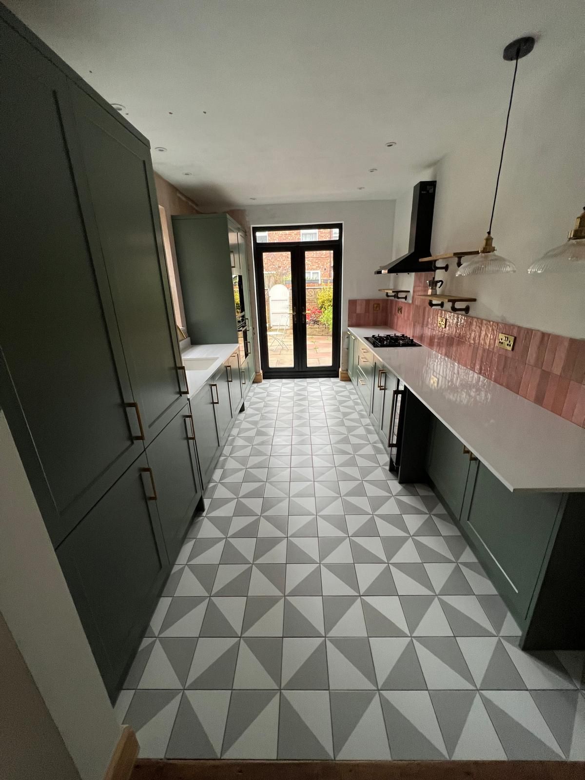 Bright modern kitchen with gray cabinets, white island, bar stools, and a window over the sink