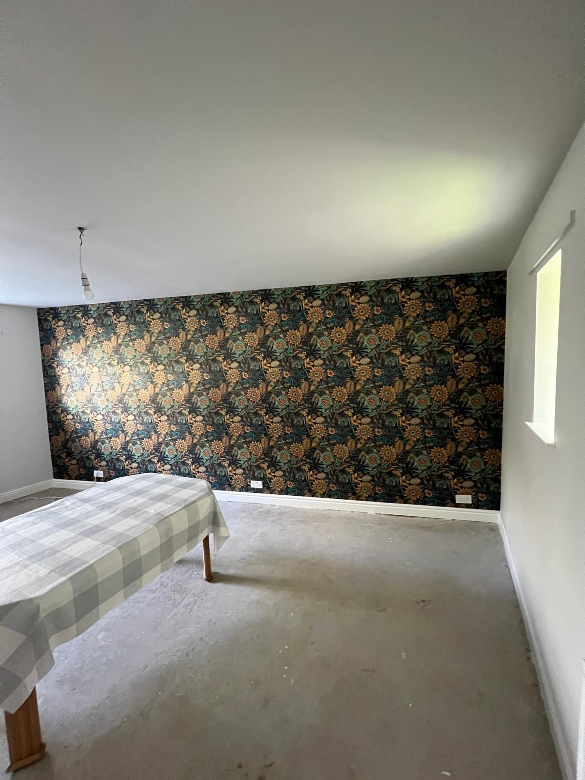 Empty room with textured gray accent wall, white trim, and carpeted floor.