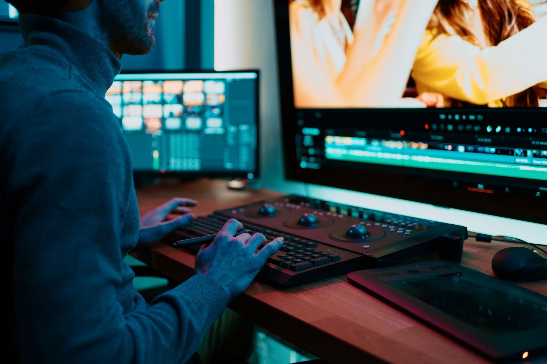 a man is sitting at a desk using a computer and a keyboard