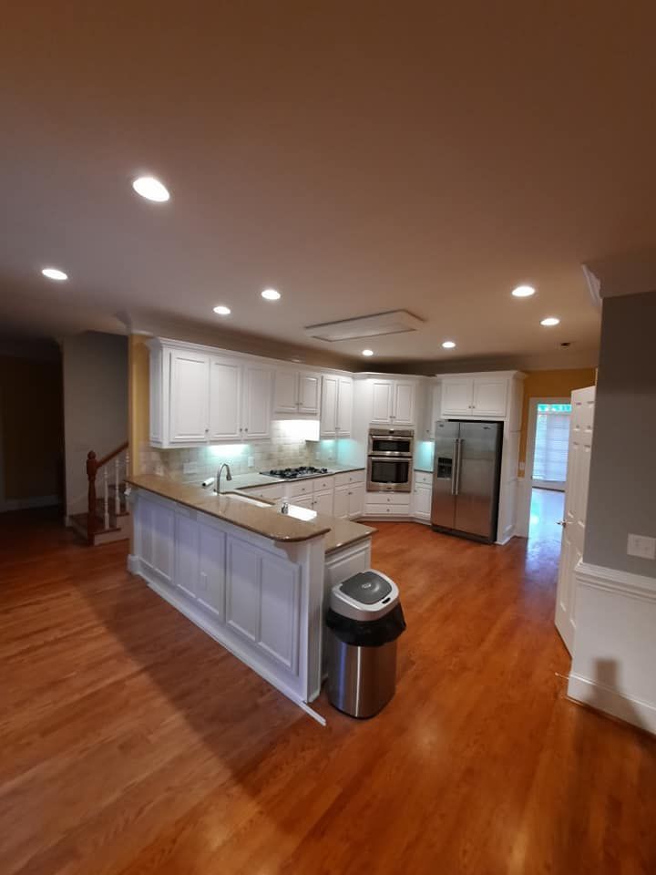 There is a trash can in the middle of the kitchen.
