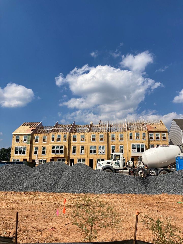 A large building under construction with a cement mixer in front of it.