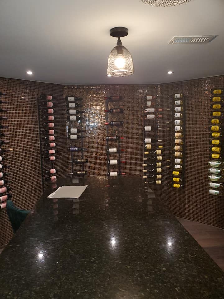 A wine cellar with lots of wine bottles hanging on the wall.