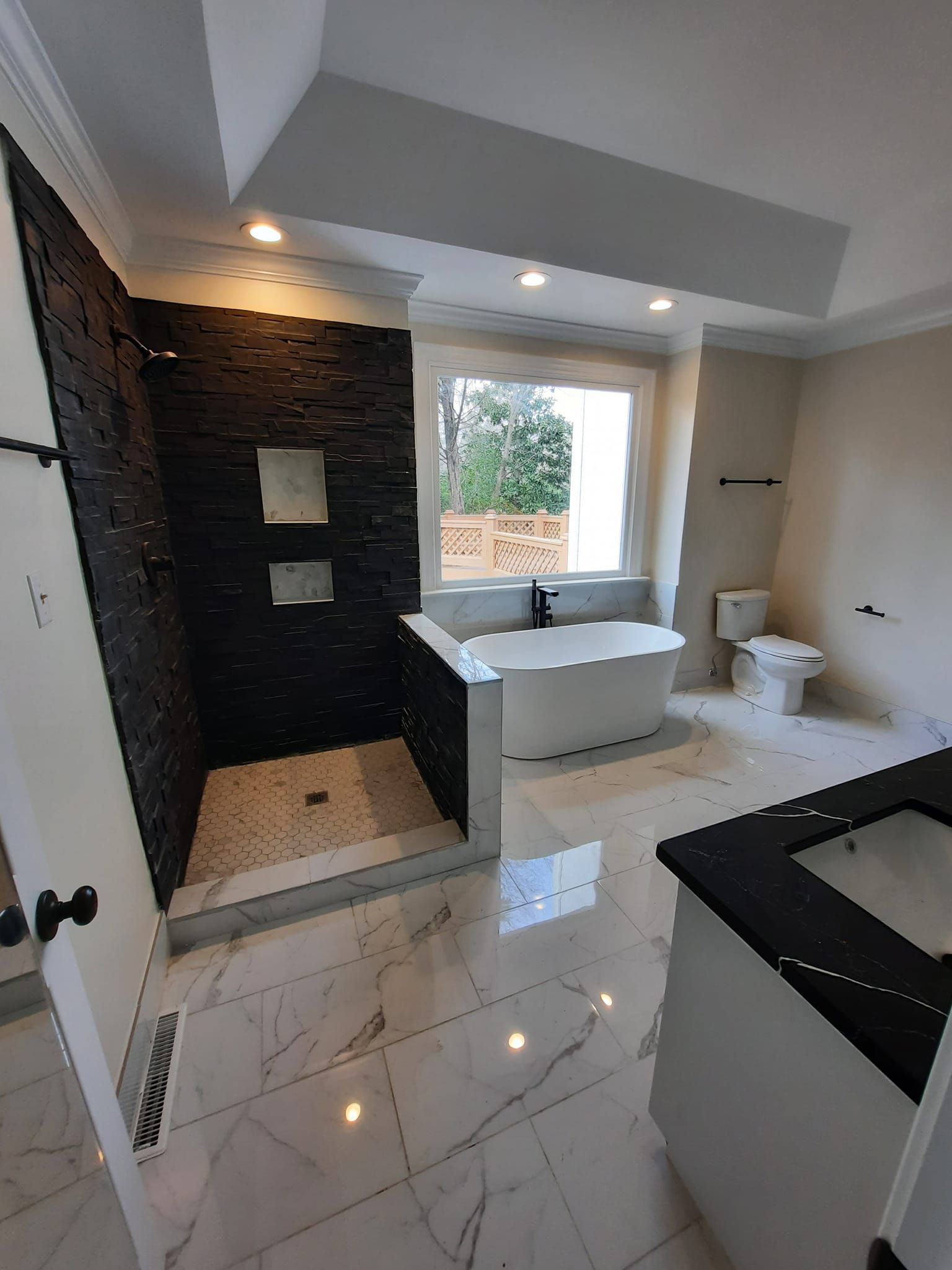 A bathroom with a tub , sink , toilet and shower.