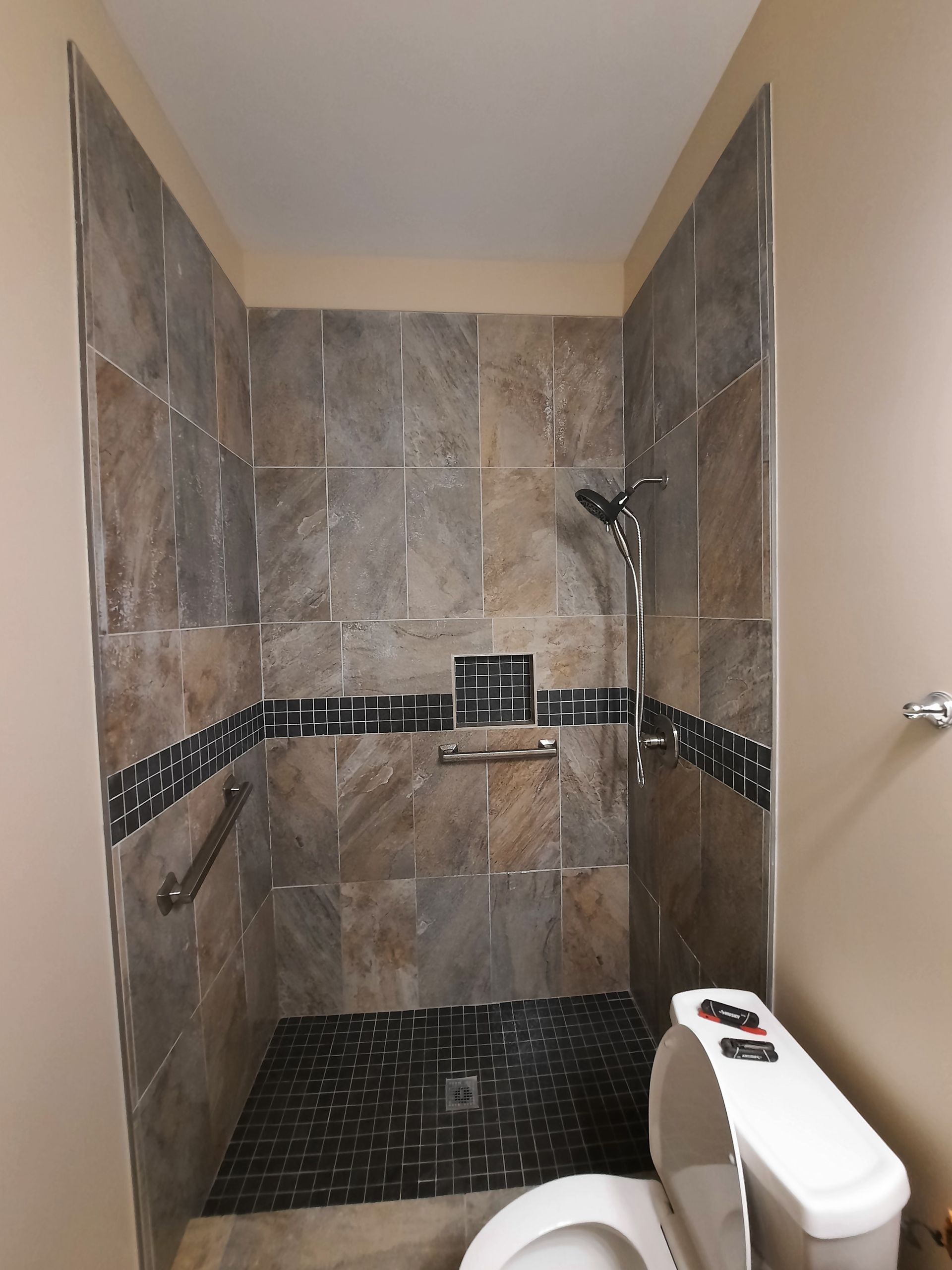 A bathroom with a toilet and a walk in shower