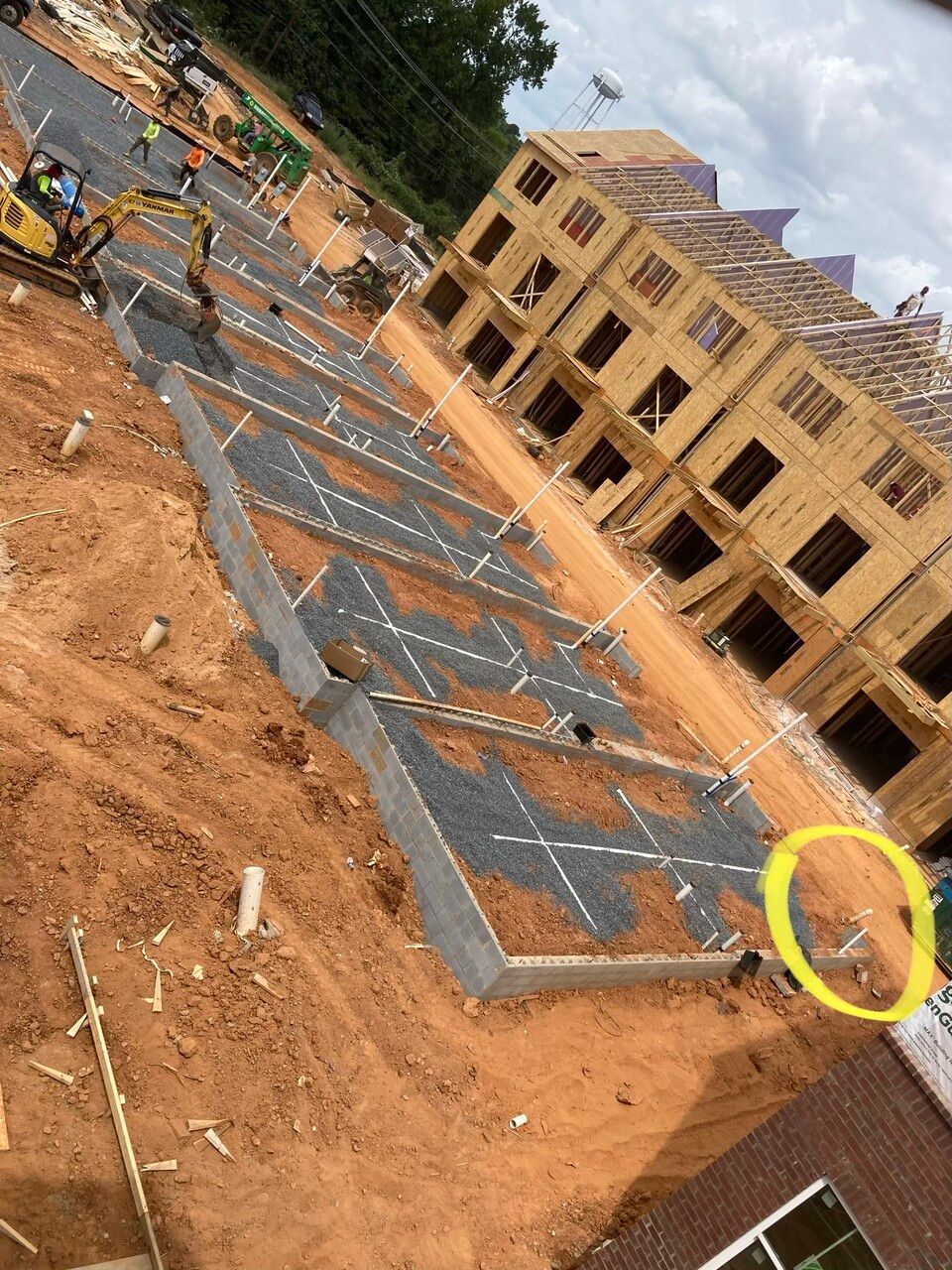 An aerial view of a construction site with a yellow circle in the middle.