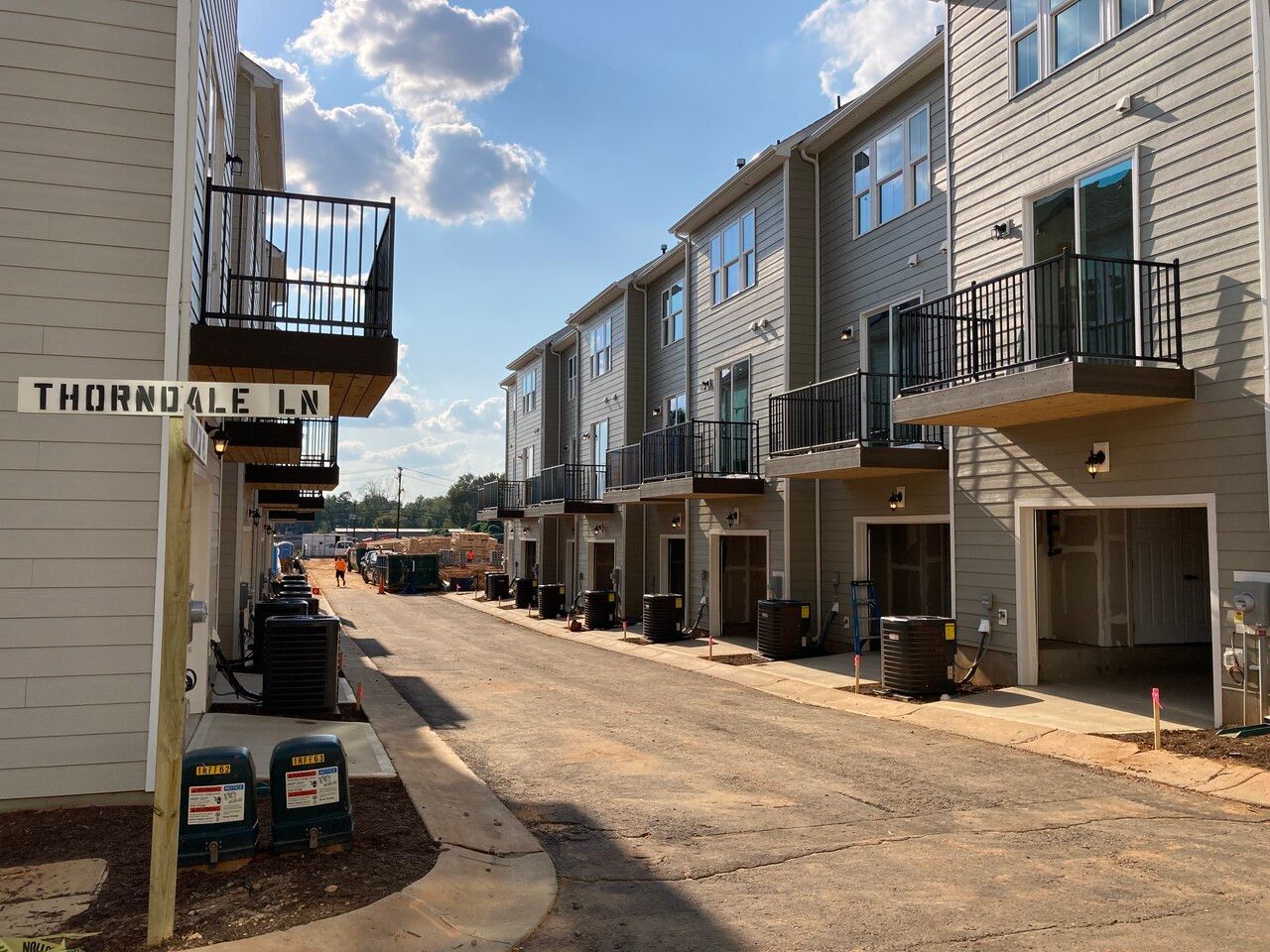 A row of apartment buildings with a street sign that says thomsdale ln