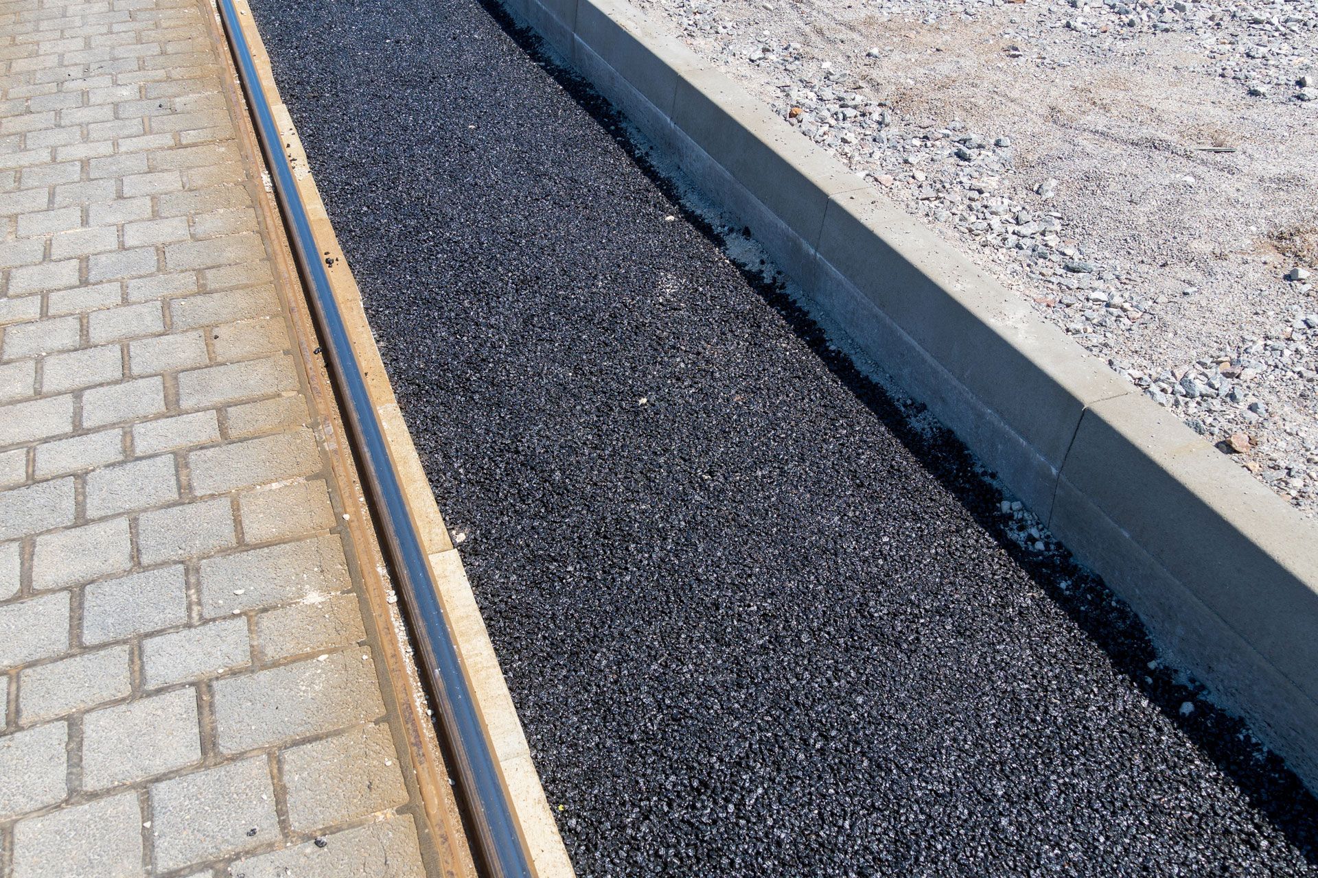 Sidewalk and gravel drainage channel with concrete borders.