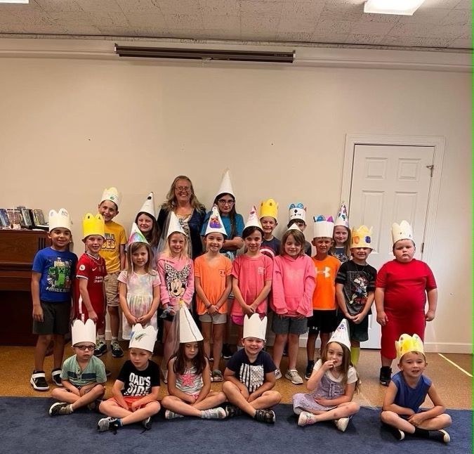 A group of children wearing party hats pose for a picture