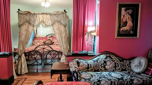 a bedroom with a canopy bed and a couch