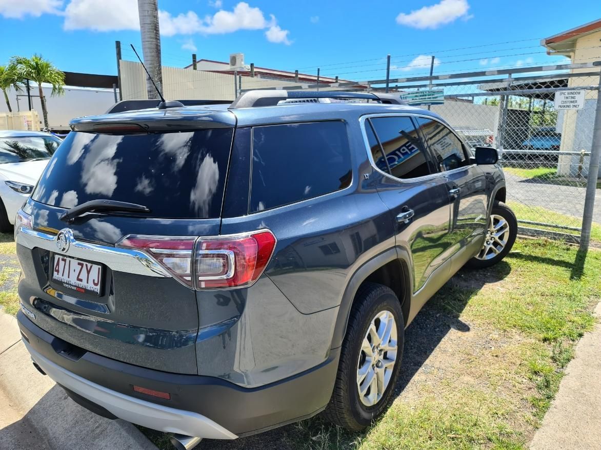 A Gray Suv Is Parked in A Grassy Area — Epic Window Tinting in Glenella, QLD
