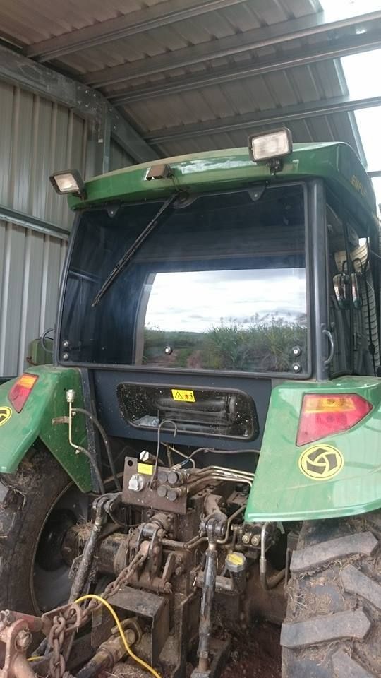 A Green Tractor is Parked in a Shed — Epic Window Tinting in Glenella, QLD