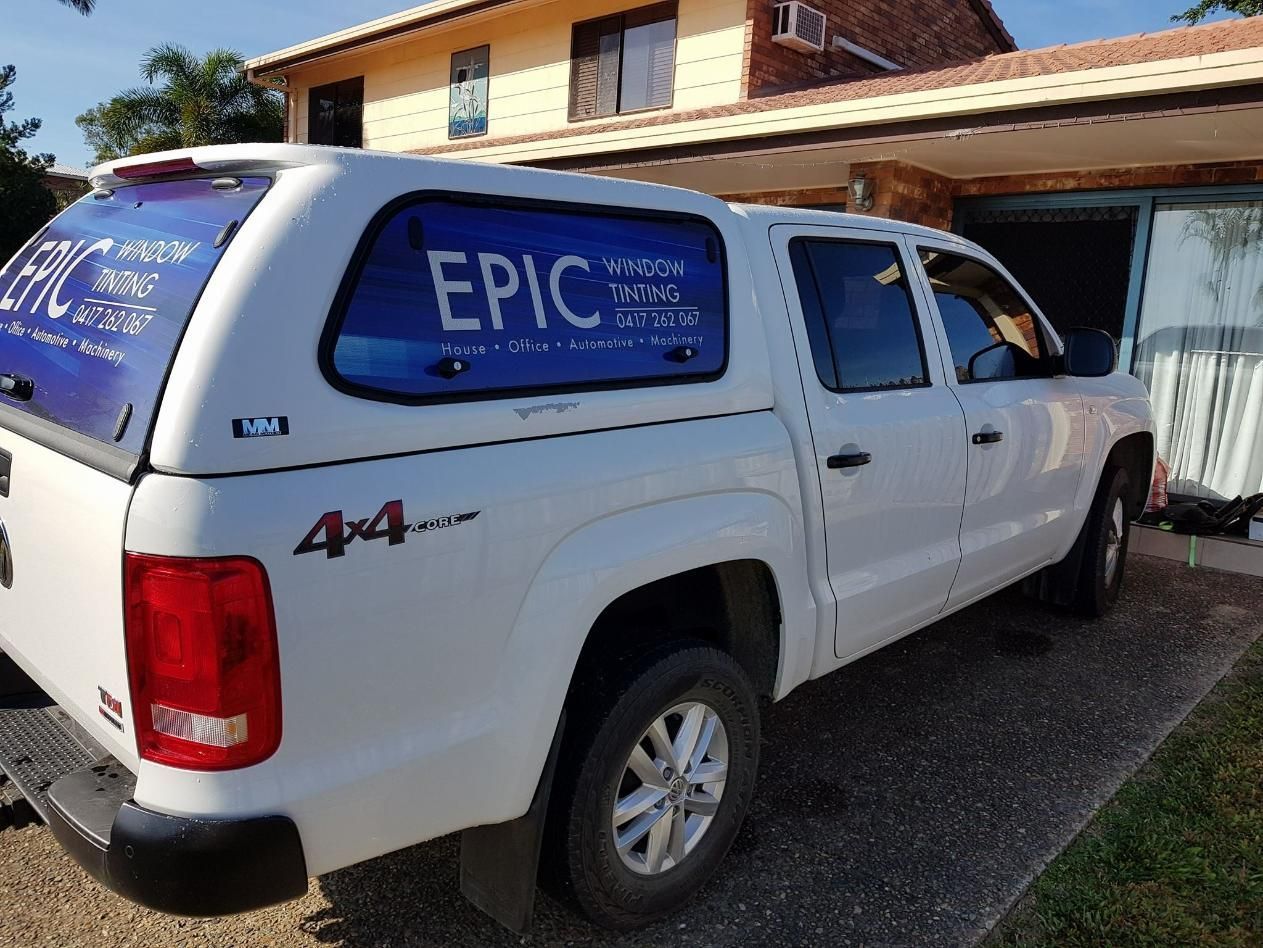 A White Truck with The Word Epic on The Side Is Parked in Front of A House — Epic Window Tinting in Glenella, QLD