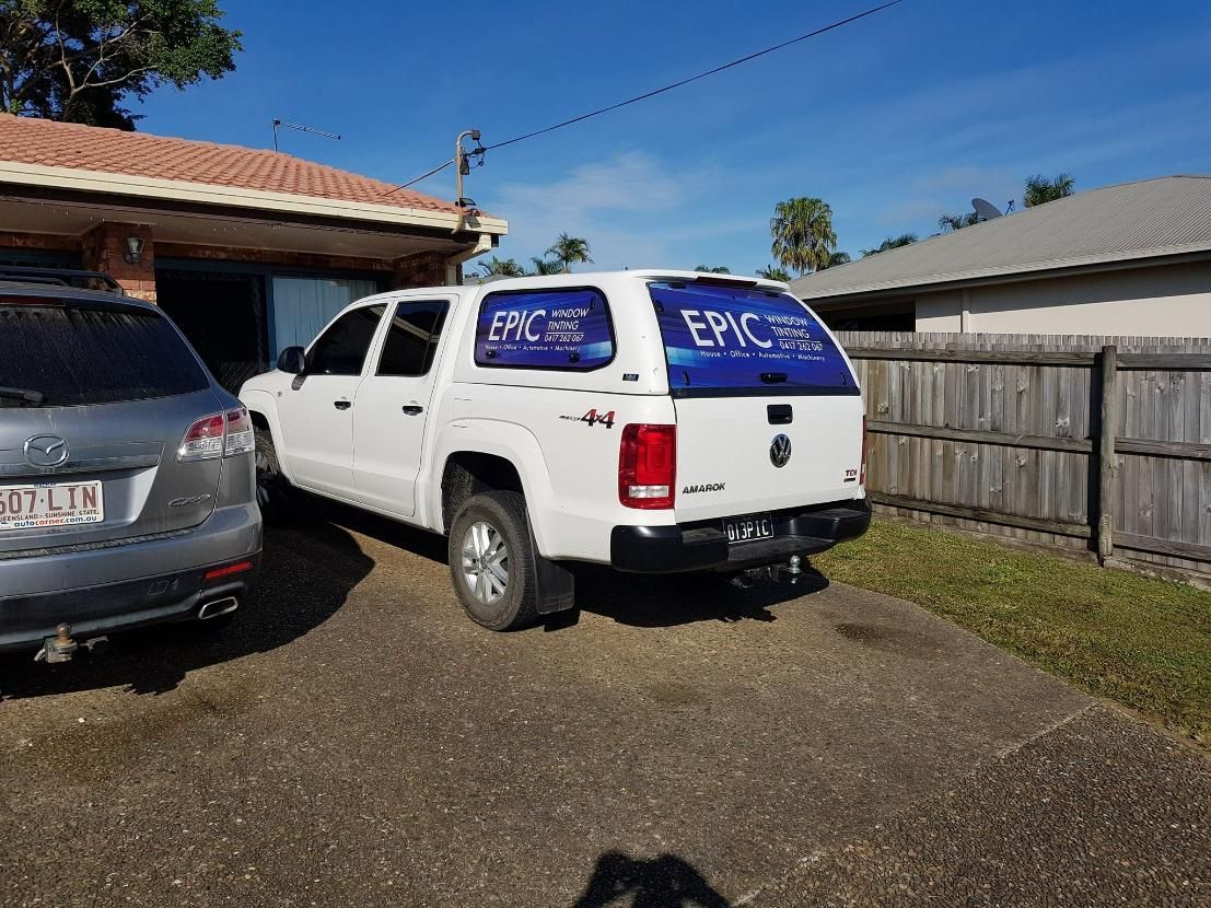 A White Truck with A Canopy Is Parked in Front of A House — Epic Window Tinting in Glenella, QLD