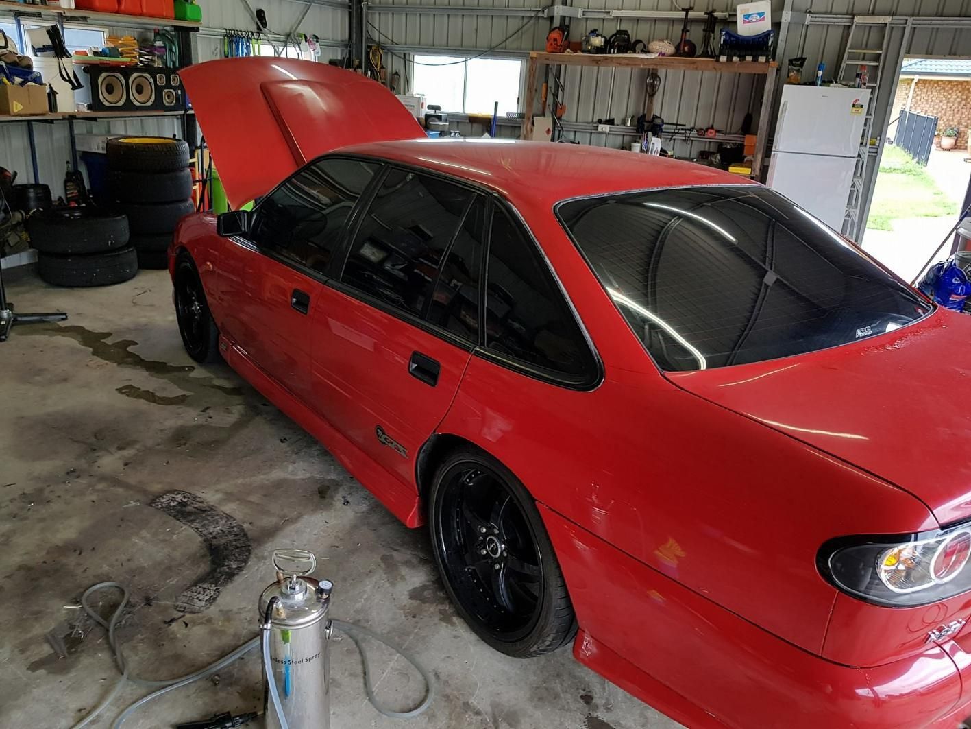 A Red Car with The Hood up Is Parked in A Garage — Epic Window Tinting in Glenella, QLD