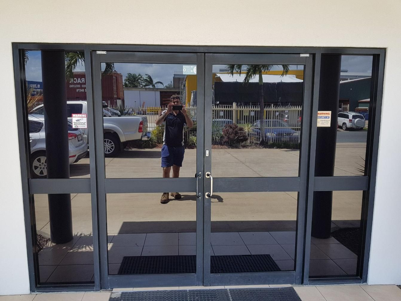 A Man Taking a Picture of Himself in A Doorway — Epic Window Tinting in Glenella, QLD