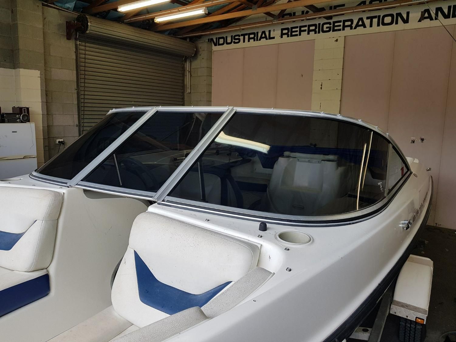 A Boat Is Parked in A Garage Under a Sign that Says Industrial Refrigeration — Epic Window Tinting in Mackay, QLD