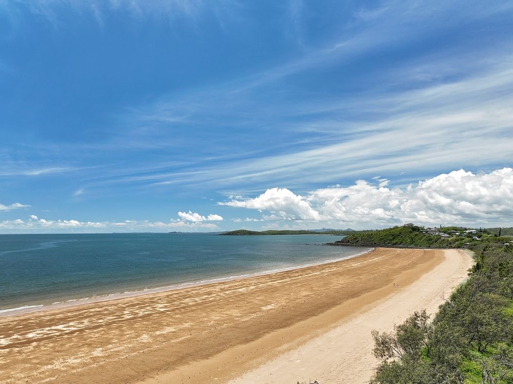 A Long Sandy Beach Next to The Ocean on A Sunny Day — Epic Window Tinting in Sarina, QLD