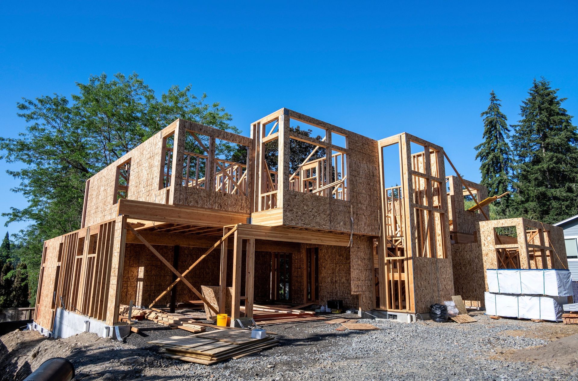 Wooden house under construction against a clear blue sky.