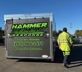 A man is walking towards a hammer hazmat response trailer