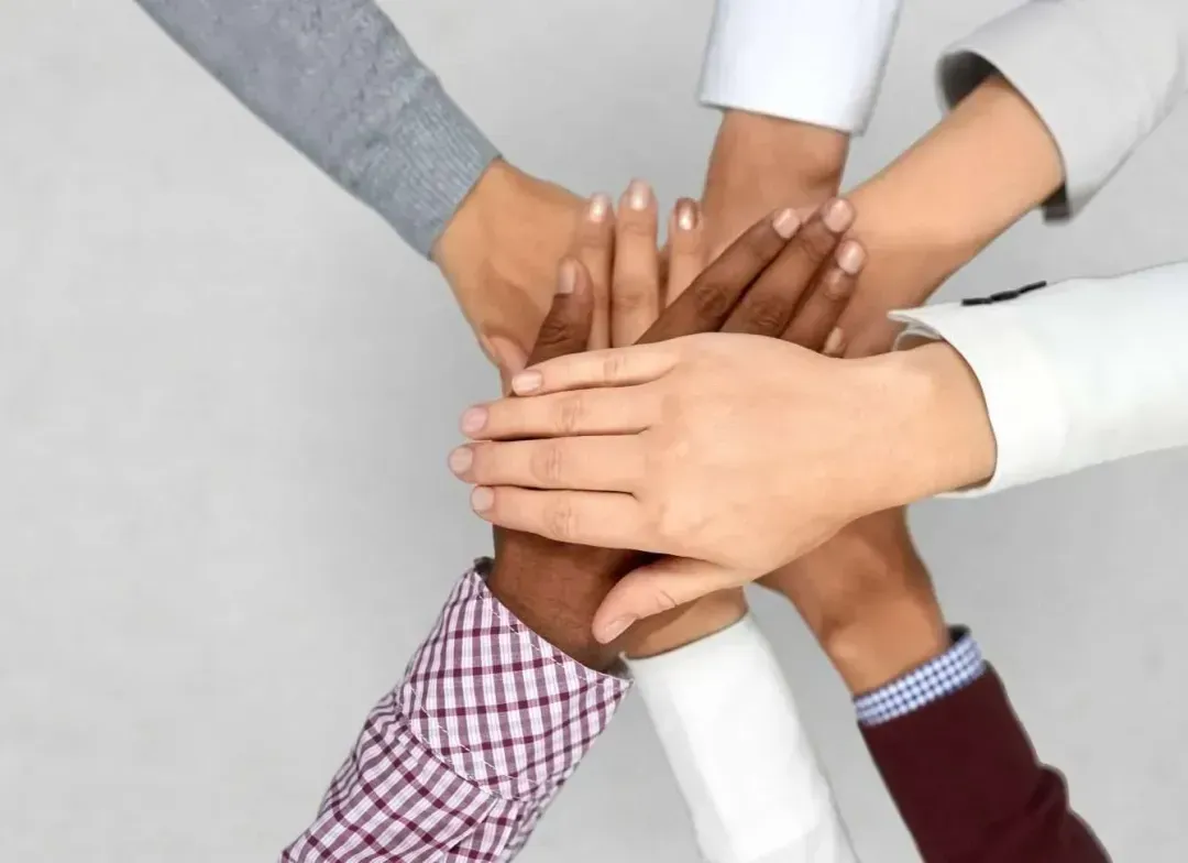 A group of people putting their hands together
