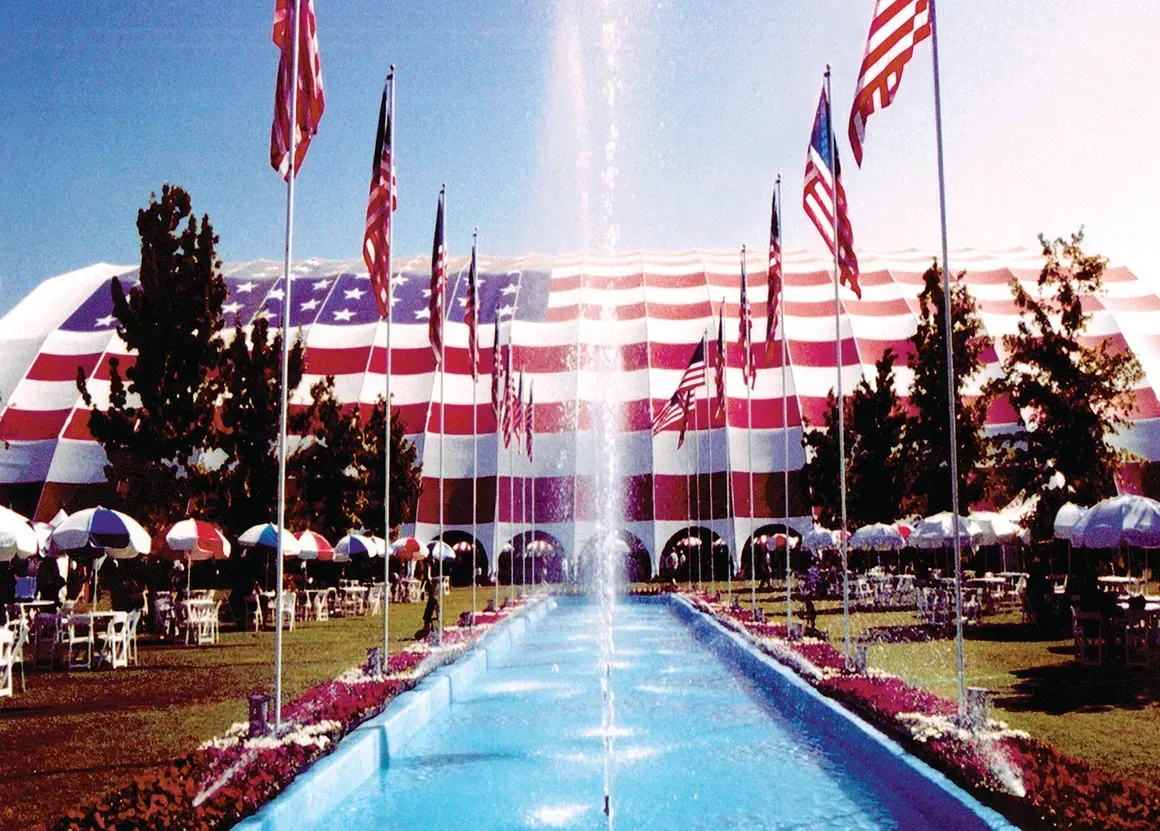 A fountain in front of an american flag covered building