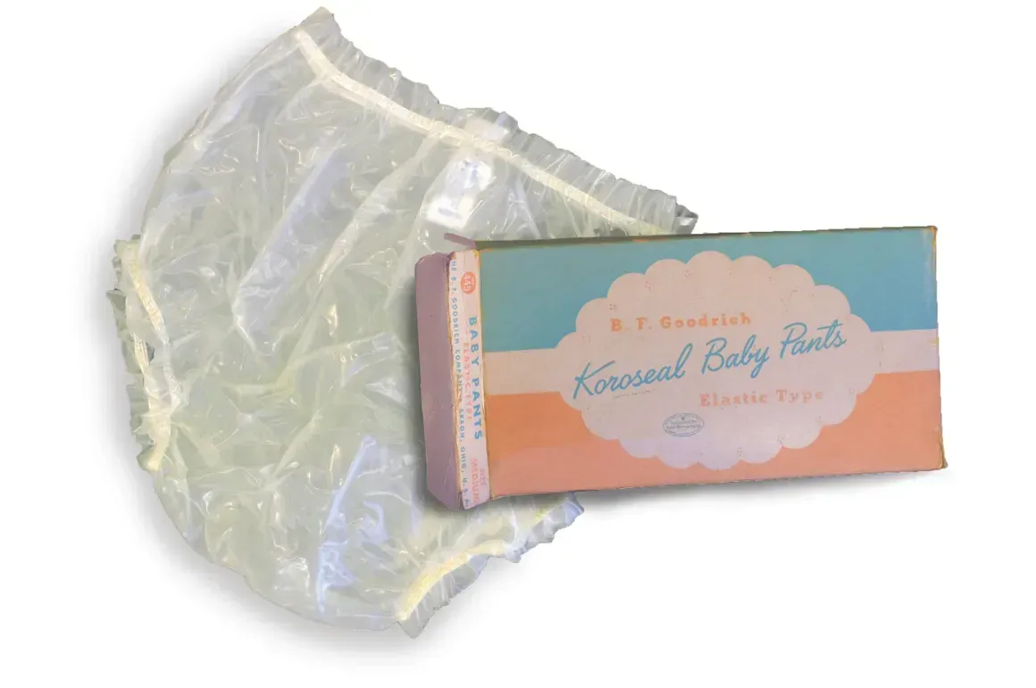 A clear plastic baby diaper is sitting next to a box that says ' krystal baby pants ' on it.