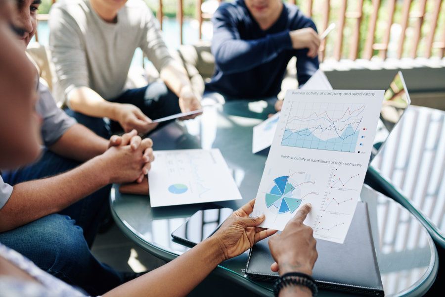 A group of people are sitting around a table looking at papers.