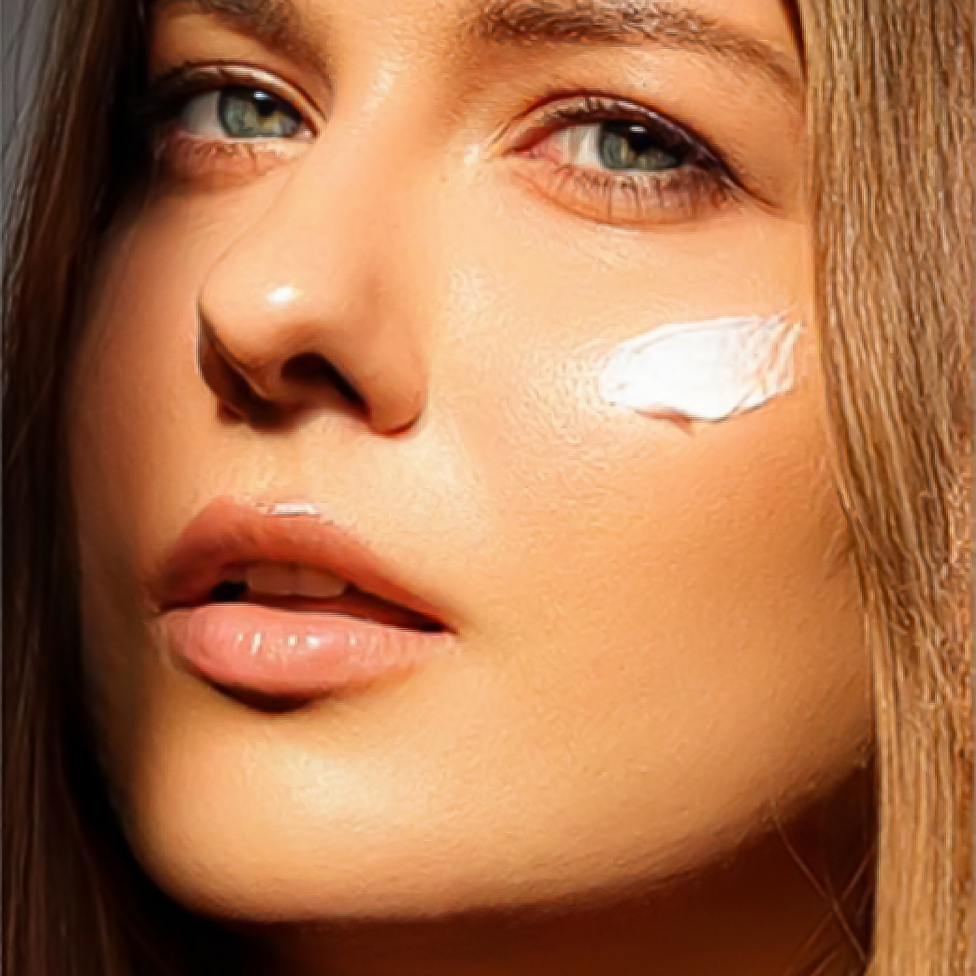 A close up of a woman 's face with cream on her face.