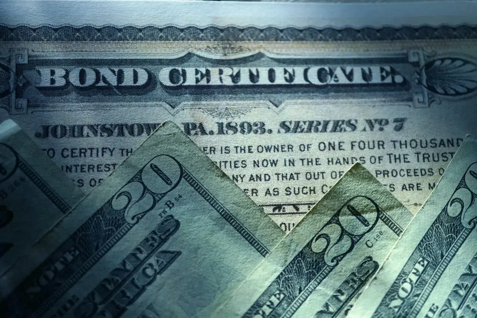 Bond certificate partially visible with twenty-dollar bills.