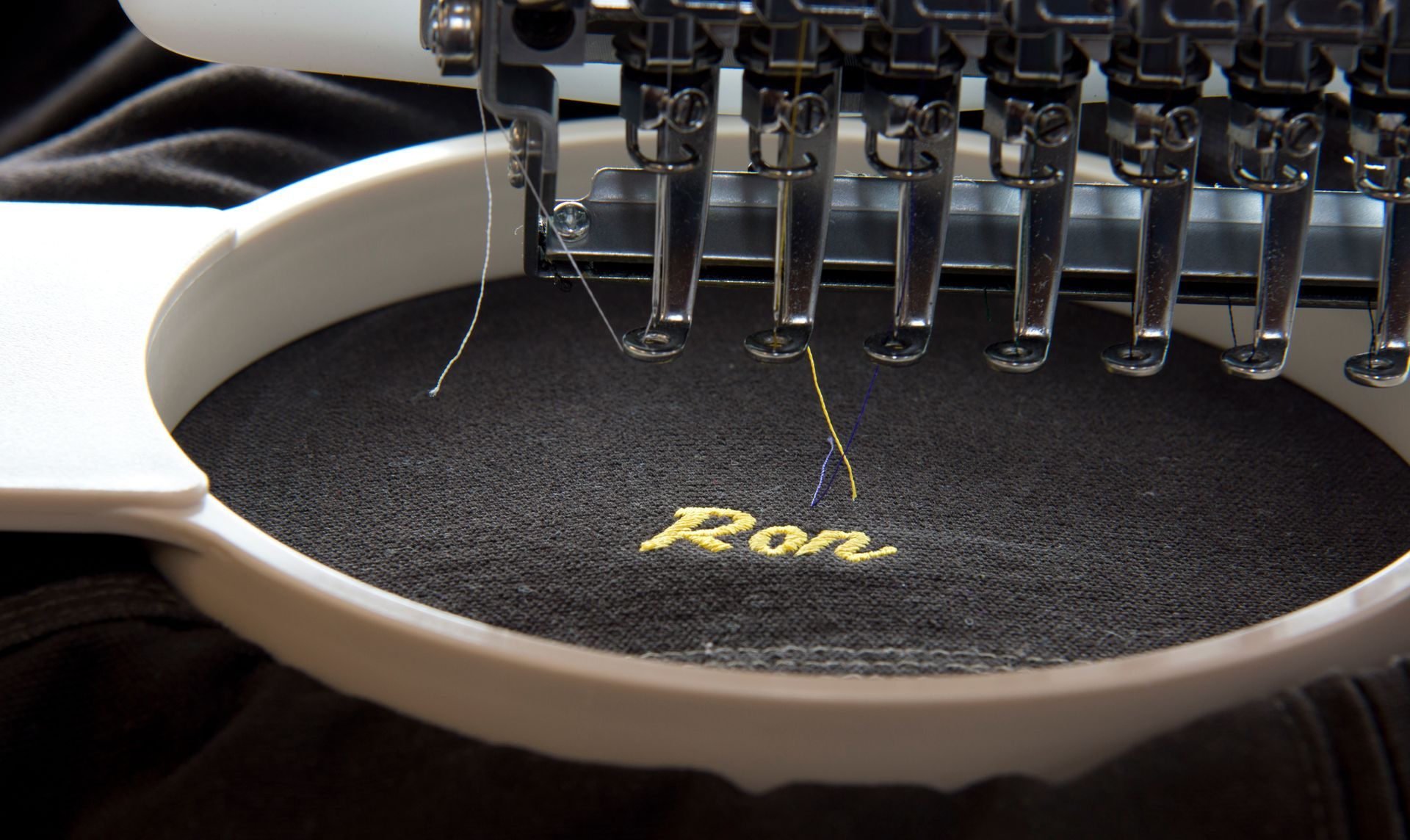 Embroidery machine just finishing a nickname on a garment.