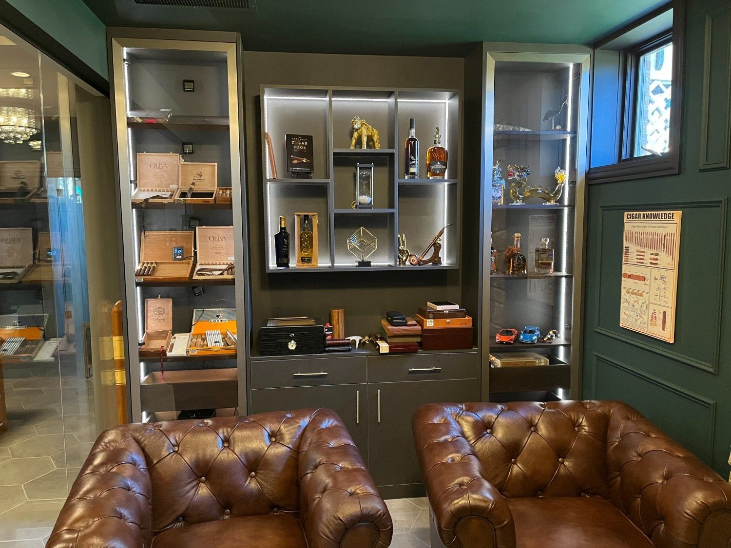 Cozy living room with leather chairs, display cabinets, and a wall-mounted TV nook