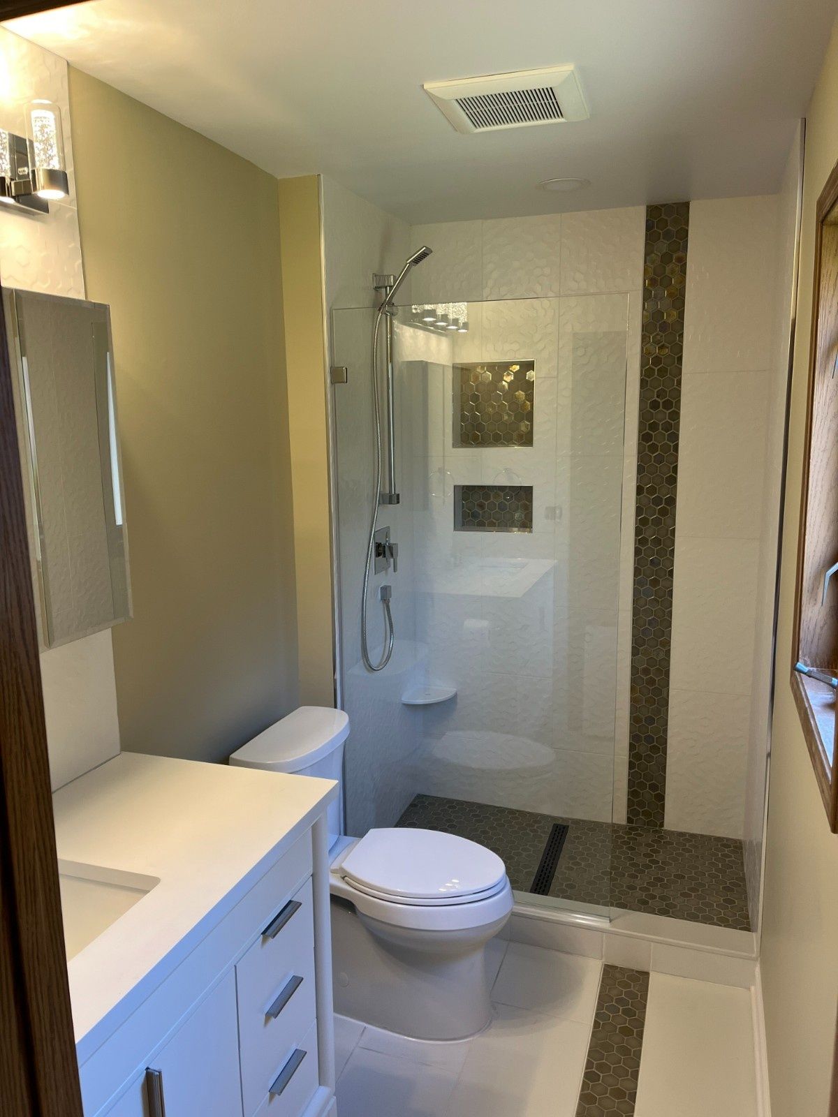Modern bathroom with vanity, toilet, and walk-in shower in beige and white tones
