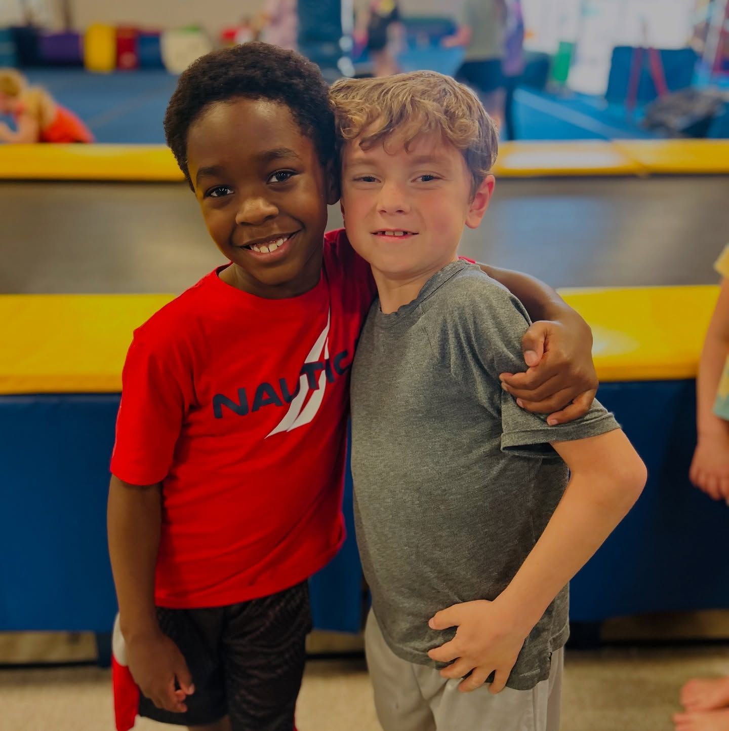 A group of young children are posing for a picture in a gym.