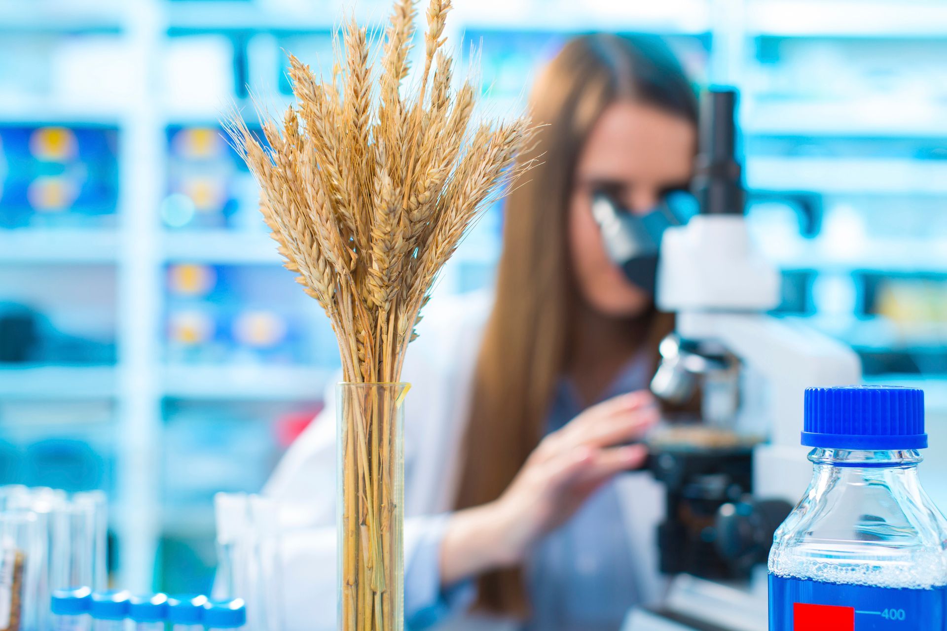 Una donna osserva attraverso un microscopio in un laboratorio.