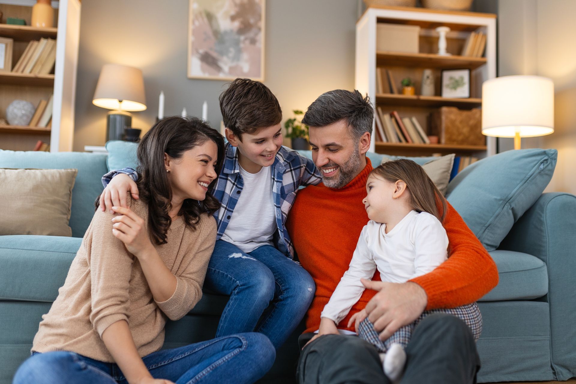 A man , woman and child are hugging each other and smiling.