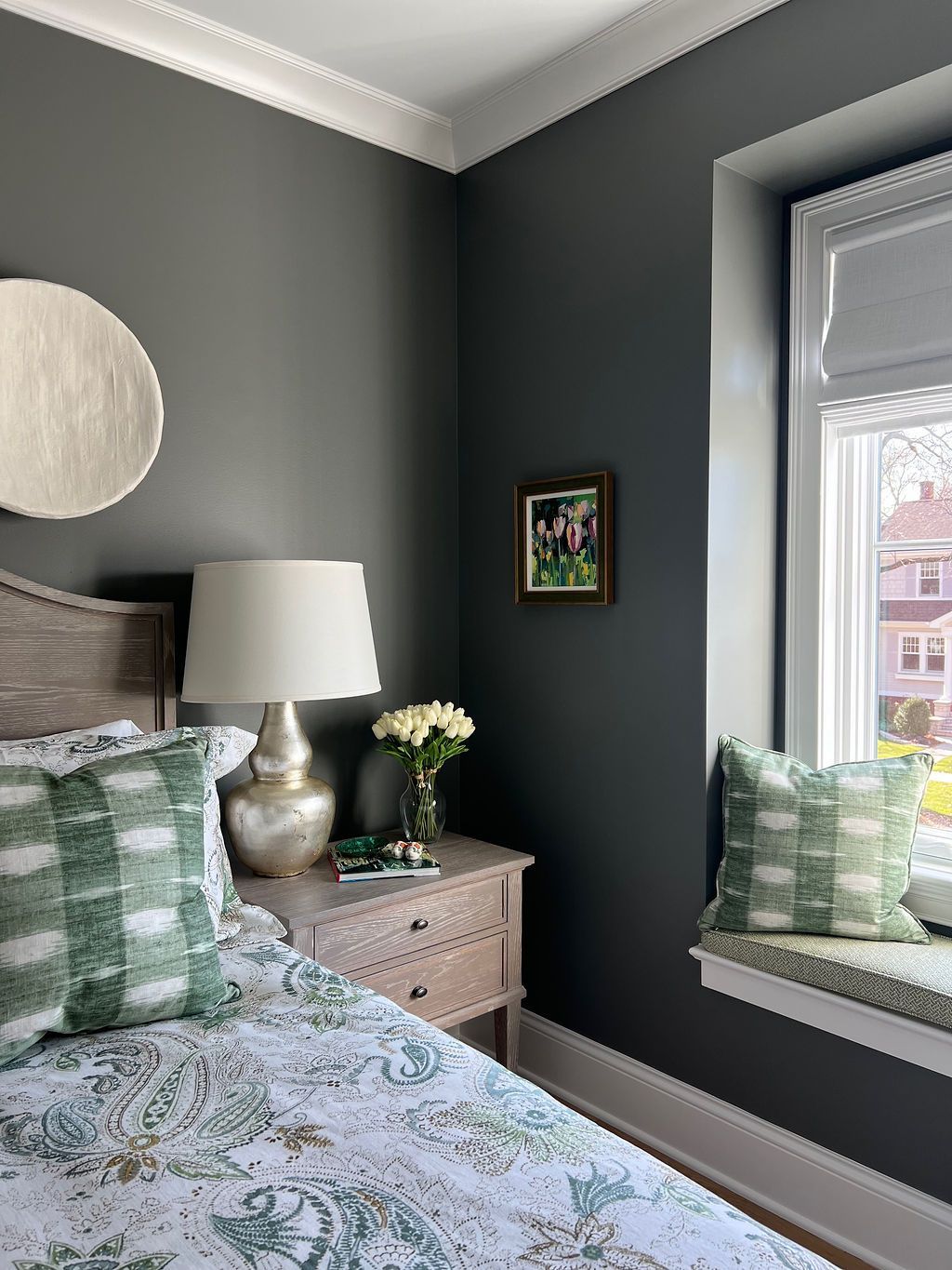 Bedroom corner with gray walls, white crown molding, light wood furniture, and green and white accents.