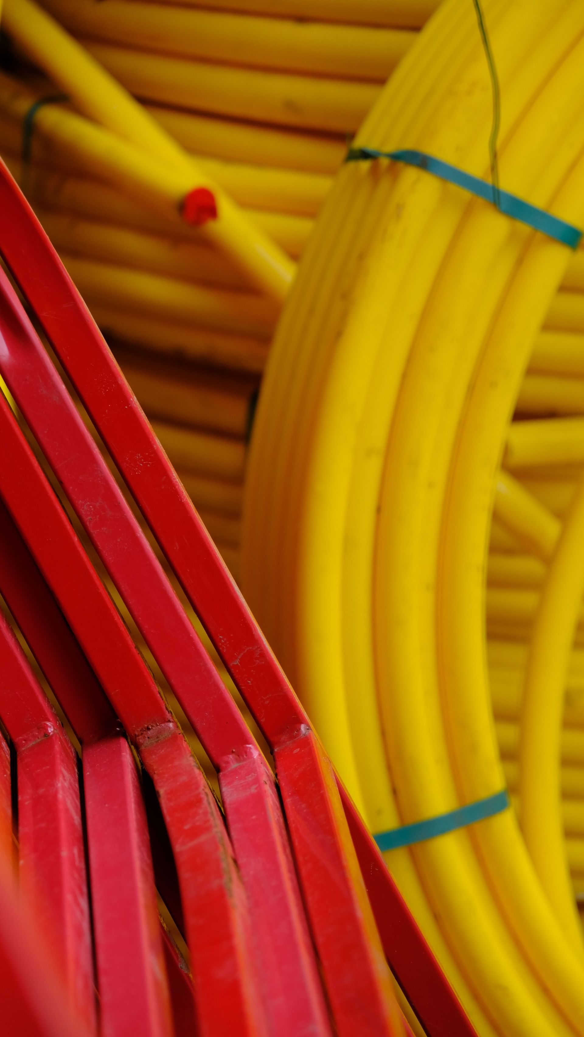 Cabos elétricos vermelhos e amarelos enrolados e agrupados com abraçadeiras azuis