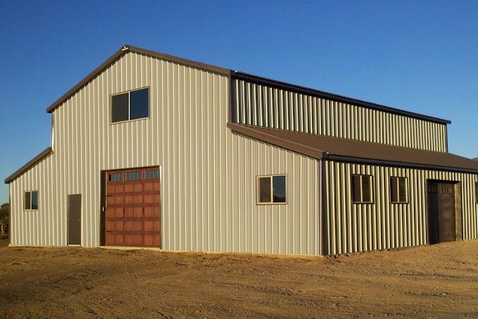 A large metal building with a brown garage door