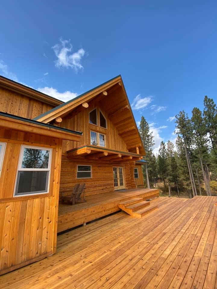 A large wooden house with a large deck in front of it.