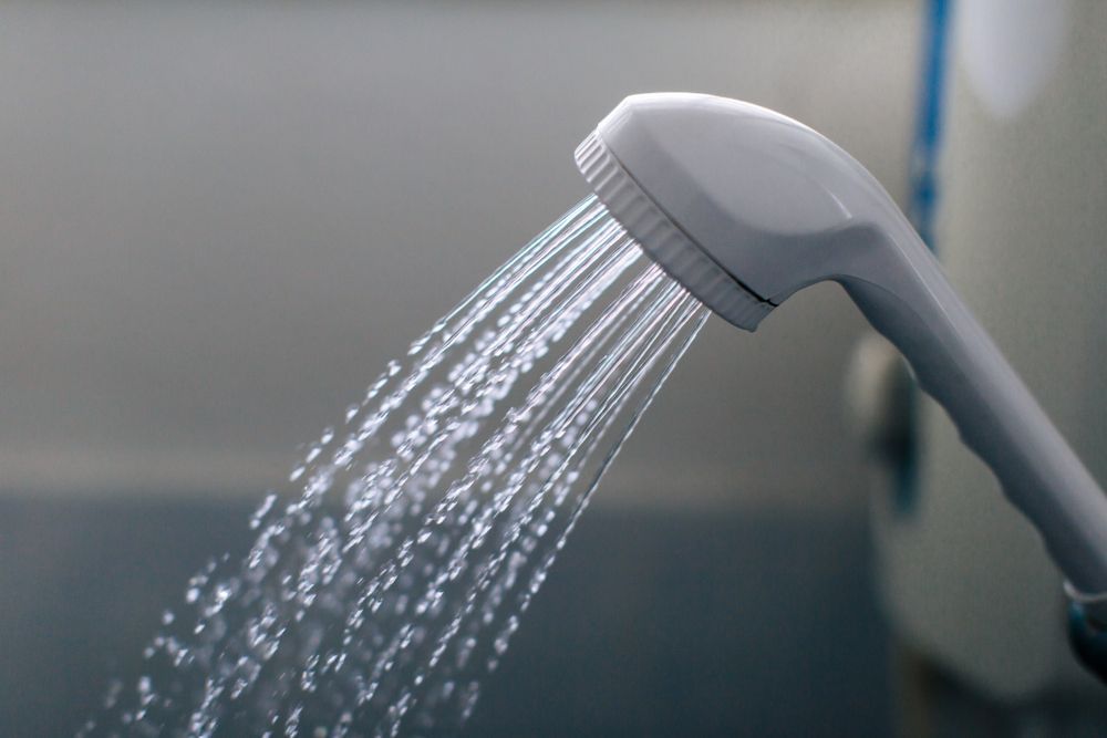 Showerhead Spraying Water; White, in A Bathroom Setting — Lakeside Gas Fridges In Maitland, NSW