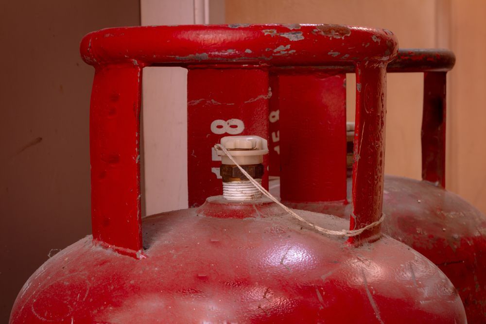 Red Propane Gas Cylinders with White Valve and Safety Seal — Lakeside Gas Fridges In Lake Macquarie, NSW