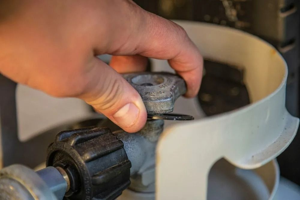 Hand Turning a Valve on A White Propane Tank — Lakeside Gas Fridges In Argenton, NSW