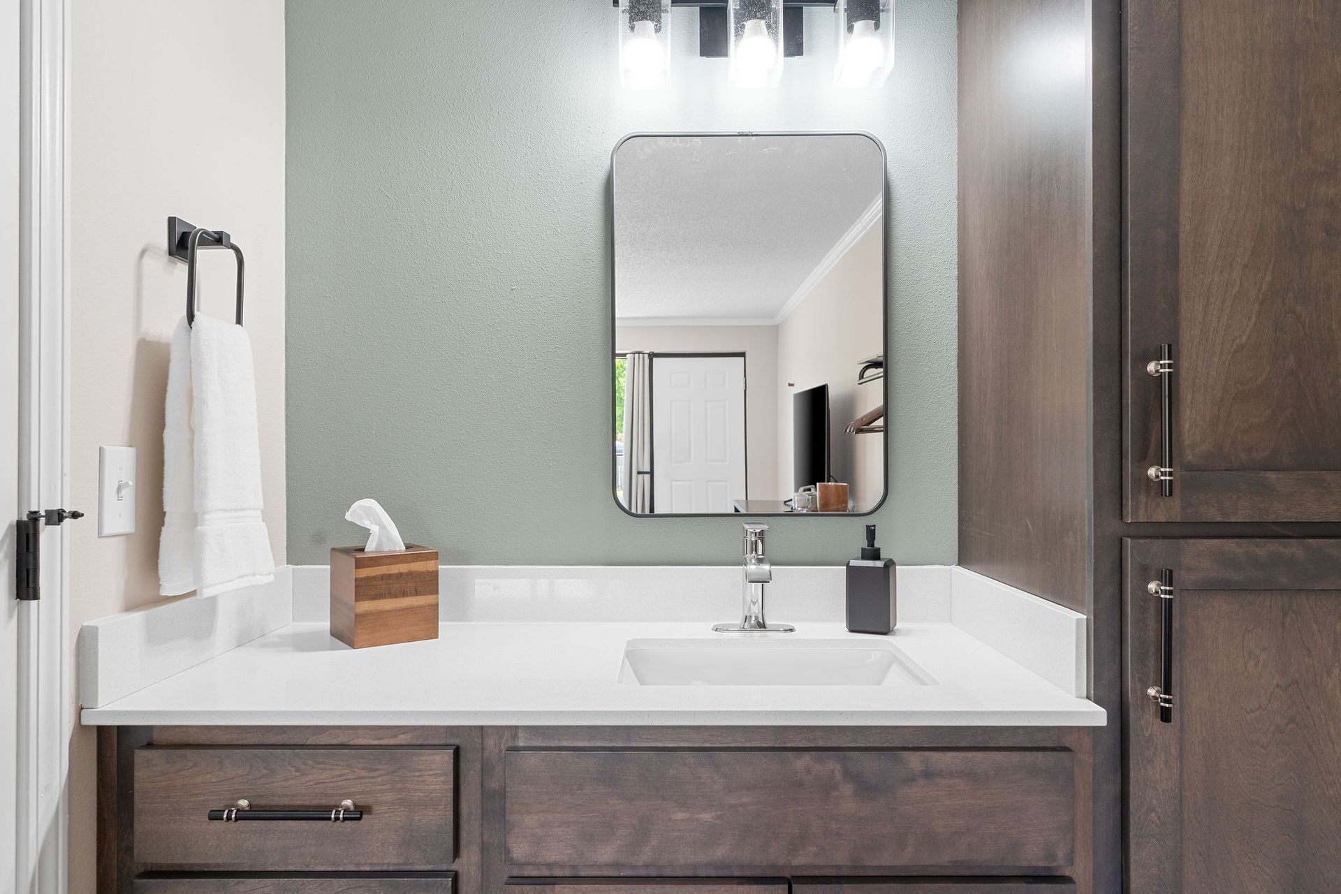 A bathroom with a sink , mirror and cabinets.