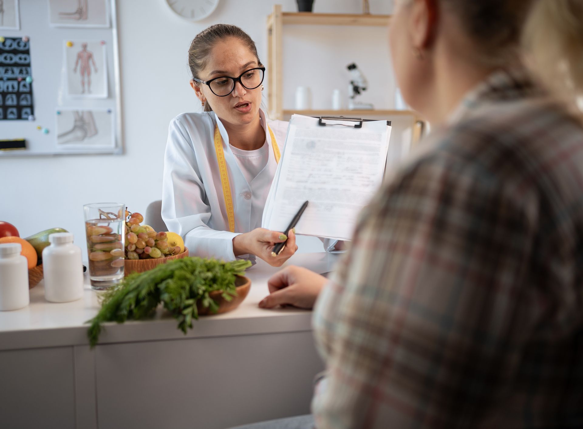 Nutritionist reviewing a meal plan and health documents with a client during a dietary consultation.