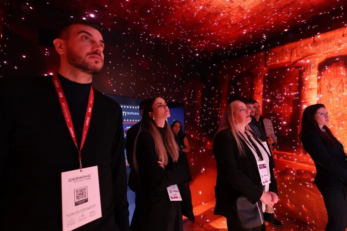 Viewers enjoy a 360 video in the immersive cube experience on a stand by Evolve