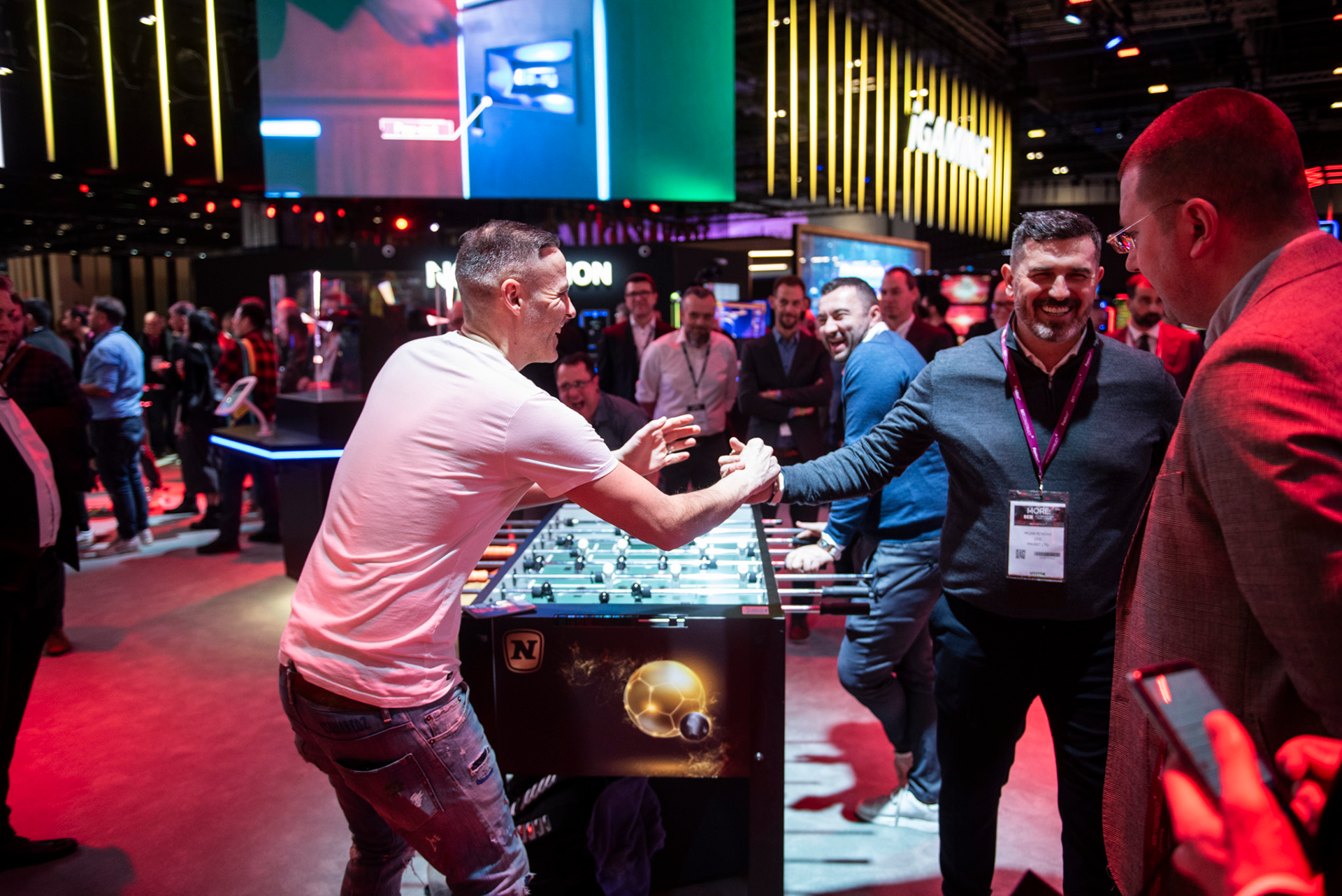 Two men celebrate at the Novomatic gaming booth at ICE London.